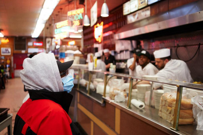 Một khách đeo khẩu trang tại nhà hàng Katz’s Delicatessen nổi tiếng ở Manhattan - Mỹ. Ảnh: NEW YORK POST