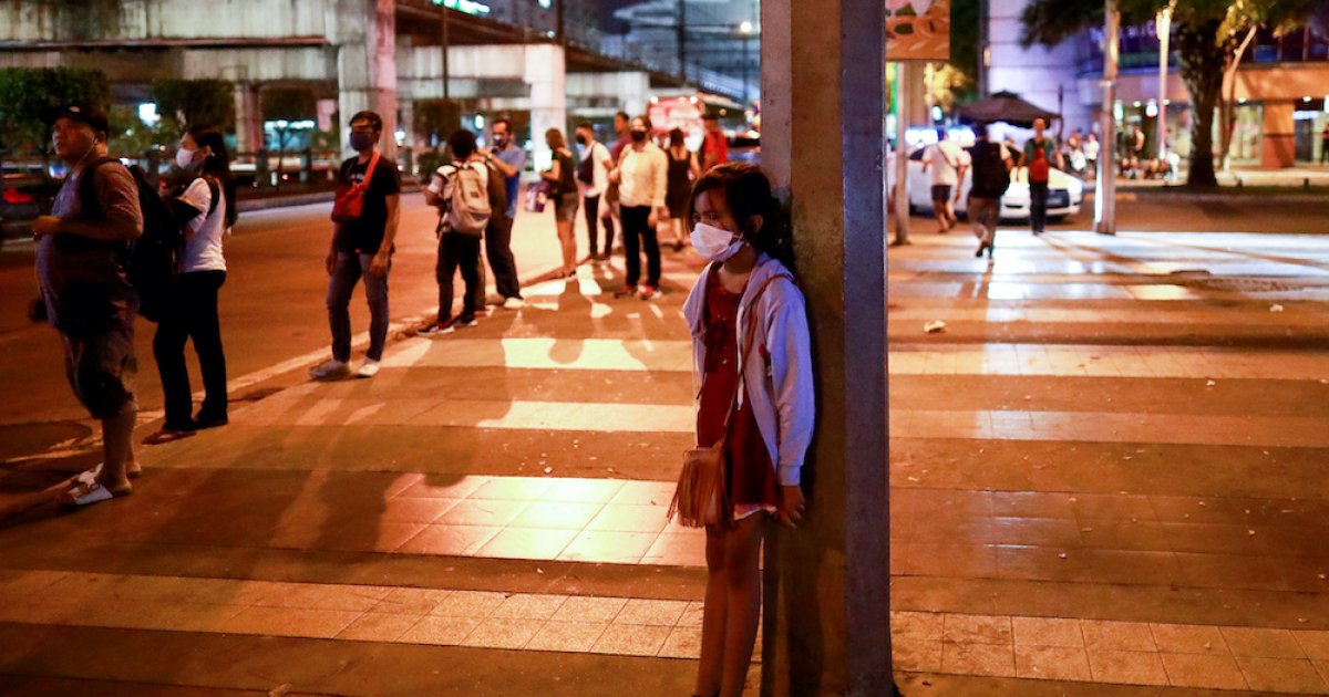 Bé gái đeo khẩu trang đứng trên vỉa hè ở Manila, Philippines, hôm 12.3 (ảnh: SCMP)