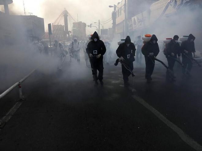 Nhân viên y tế khử trùng khu vực phía Tây thủ đô Tehran, Iran ngày 13-3. Ảnh: REUTERS