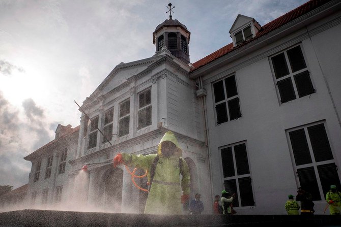 Nhân viên phun thuốc khử trùng ở Jakarta, Indonesia ngày 22.3.