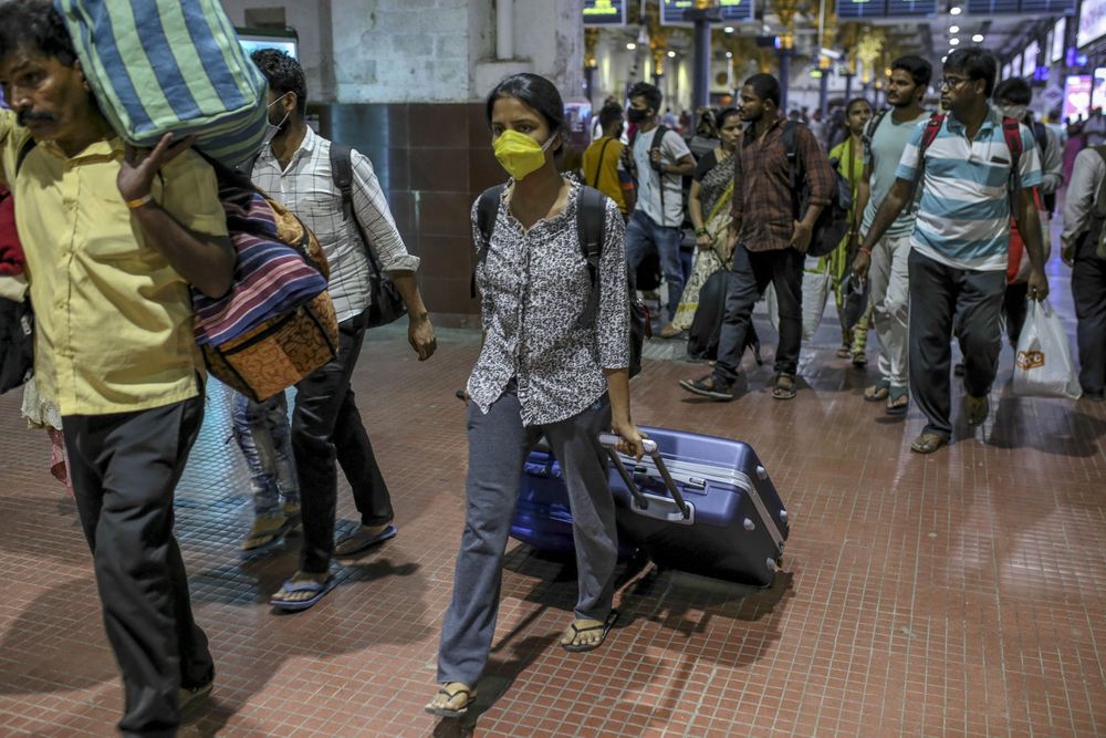 Người dân mang theo hành lí đến nhà ga ở Mumbai, Ấn Độ hôm 21.3.