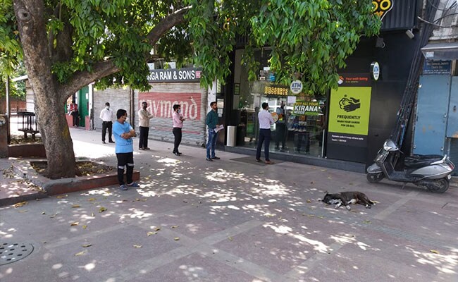 Khách đứng bên ngoài một cửa hàng ở Delhi vẫn đang mở cửa. Tuy nhiên, ai cũng giữ khoảng cách với người phía trước.