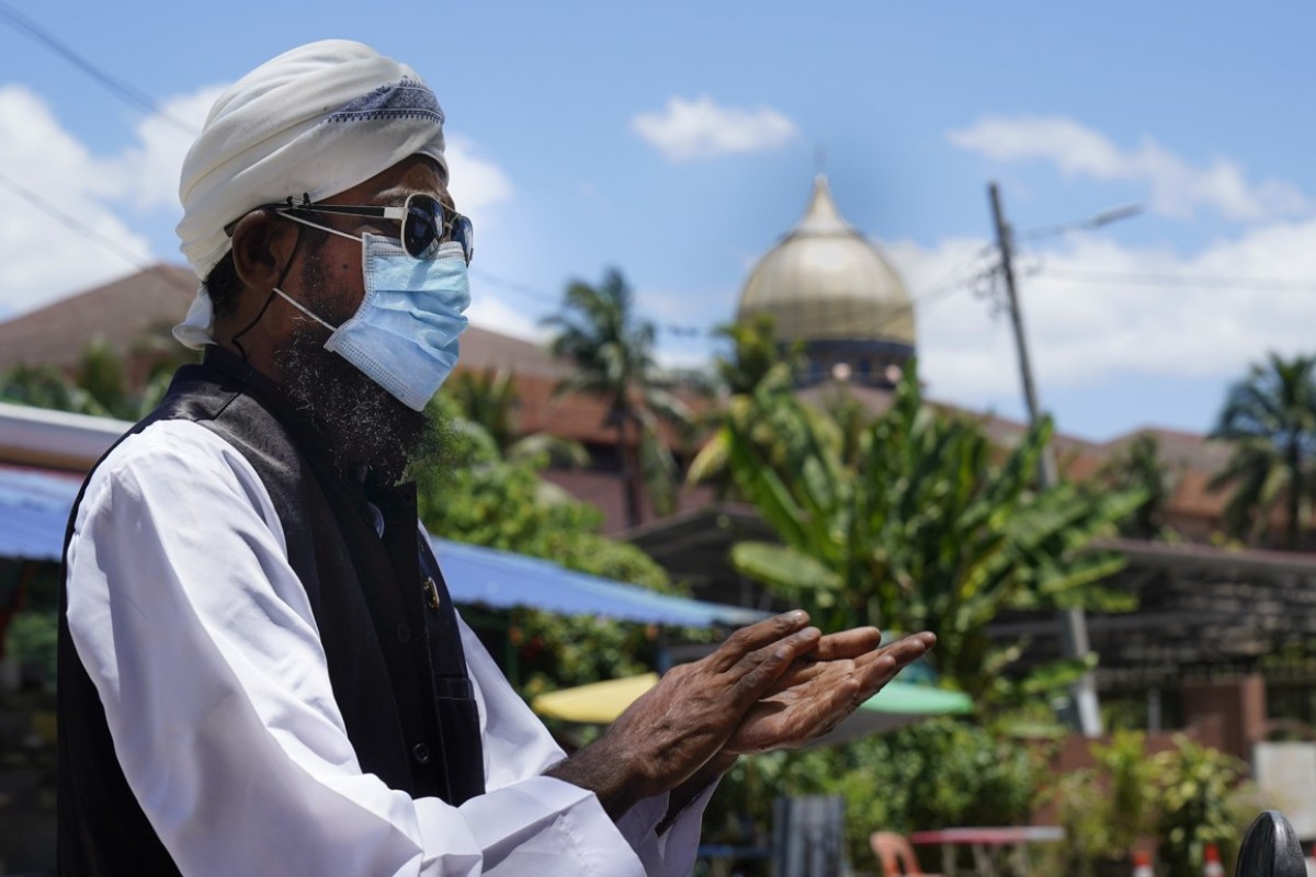 Một người đàn ông đeo khẩu trang, khử trùng tay tại&nbsp;Kuala Lumpur (ảnh: Straitstimes)
