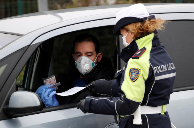 Cảnh sát kiểm tra hoạt động đi lại của người dân ở TP Molfetta - Ý hôm 25-3 Ảnh: REUTERS