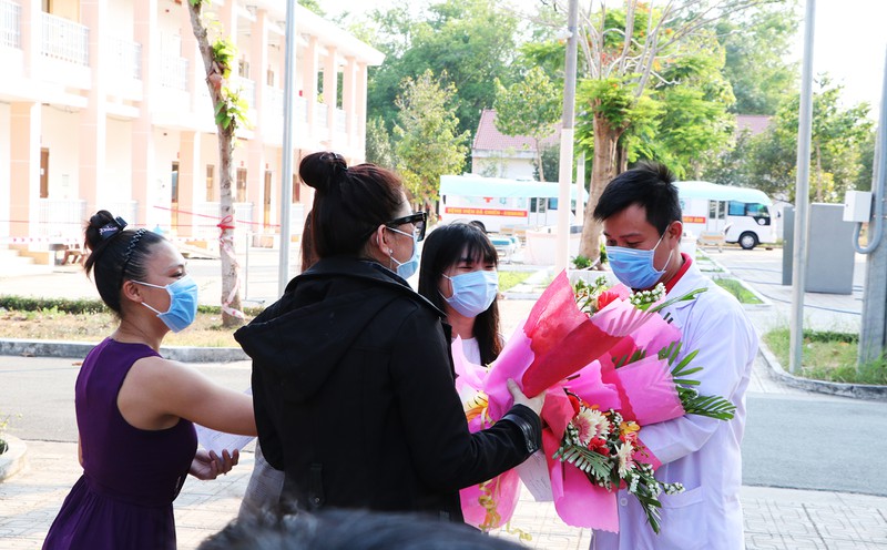 Những người được xuất viện tặng hoa cho bác sĩ ở Bệnh viện dã chiến Củ Chi, TP.HCM . Ảnh: PLO