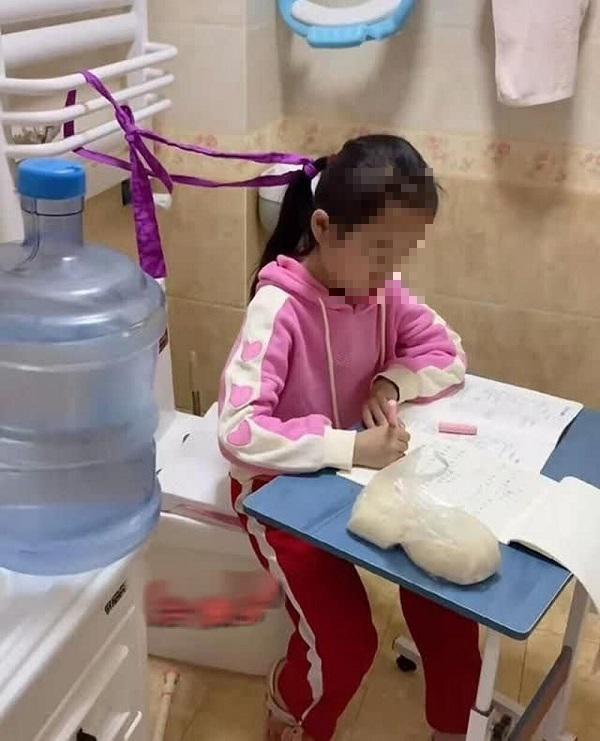 Cô bé được mẹ chuyển chỗ học vào nhà vệ sinh.