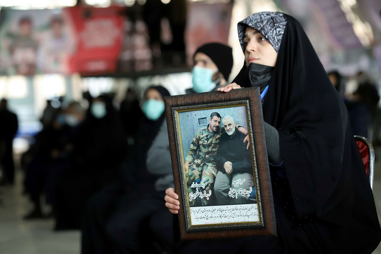 Một cô gái mang ảnh của tướng Qassem Soleimani tham gia lễ tưởng niệm tổ chức ở Tehran (ảnh: SCMP)