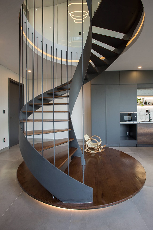 Cầu thang xoắn dẫn lối lên tầng 1 không chỉ đáp ứng về mặt công năng sử dụng mà còn mang tính thẩm mỹ, khiến không gian tầng trệt có điểm nhấn ấn tượng.
