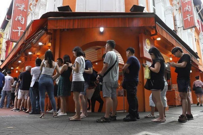 Xếp hàng dài hoặc đợi qua đêm bên ngoài các cửa hàng bánh nướng Lim Chee Guan là cảnh thường thấy trong những dịp Tết (Nguồn: Straits Times)
