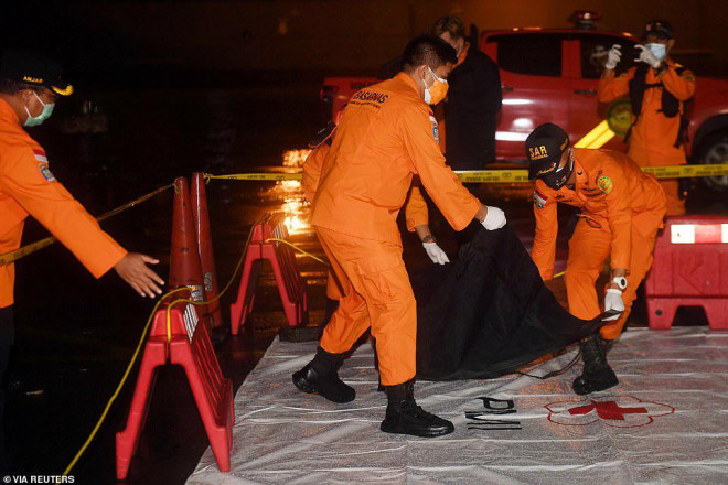 Nhân viên tìm kiếm và cứu hộ Indonesia mang túi có mảnh vỡ được cho là của chiếc máy bay gặp nạn&nbsp;tại cảng Tanjung Priok ở Jakarta, đầu ngày 10-1. Ảnh: Reuters