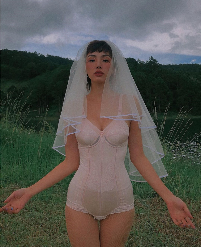 Gigi Hương Giang được biết đến với biệt danh "cô dâu Hà Nội", ấn tượng trong những bức ảnh theo concept "cô dâu gợi tình" với bộ nội y màu nude, điểm nhấn là chiếc voan cài đầu trắng.
