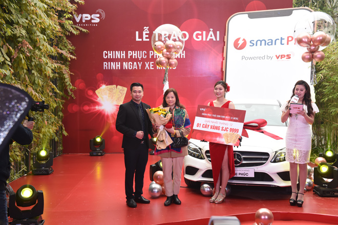 Chủ nhân của giải thưởng tháng 12 - khách hàng Dương Thị Xuân Yến (đứng thứ hai từ trái sang) và đại diện VPS, ông Vũ Đức Long - Giám đốc Tư vấn Đầu tư lên trao giải.