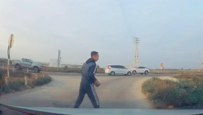 Tài xế xe ô tô chủ động dừng lại, đưa viên gạch rơi vãi ra vệ đường. (Ảnh: FB Trần Việt Hùng)