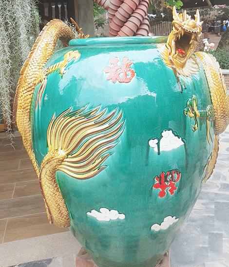 Hình ảnh con rồng và hoa văn trên một bình gốm với chất men màu ngọc lam.