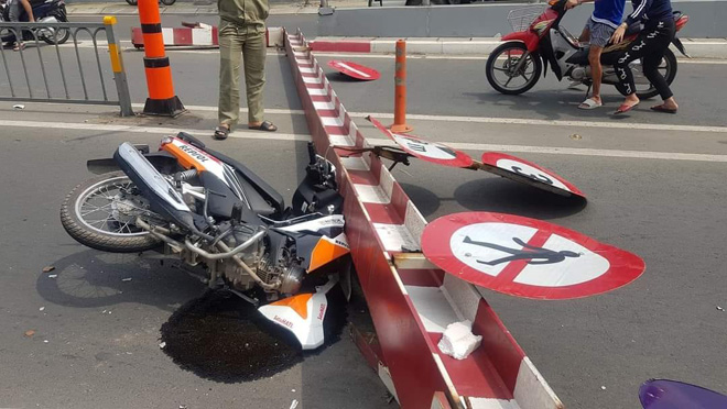 Phần đầu xe máy bị thanh chắn đè hư hỏng.