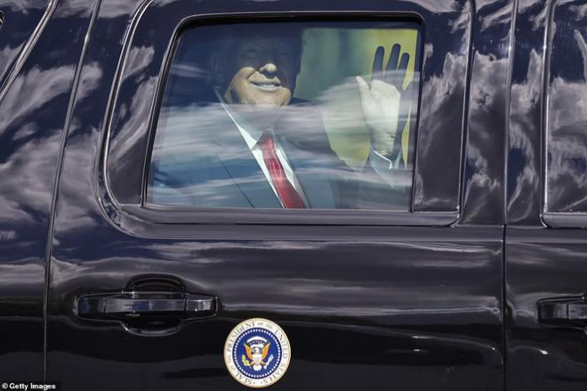 Ông Trump sau đó xuất hiện trong xe hơi, tươi cười vẫy chào những người ủng hộ. Ảnh: Getty