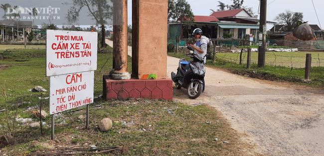 Bảng cấm mua bán chó, tóc dài, điện thoại hỏng được gắn bên cổng làng Nhĩ Trung. Ảnh: Ngọc Vũ