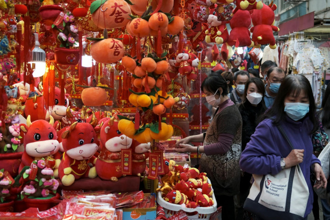 Người dân Hồng Kông (Trung Quốc) đeo khẩu trang đi mua sắm chuẩn bị Tết nguyên đán hôm 28-1 Ảnh: REUTERS
