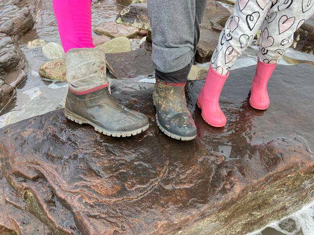 Lily ướm chân mình lên dấu chân "quái thú" kỷ Tam Điệp - Ảnh: WALES ONLINE