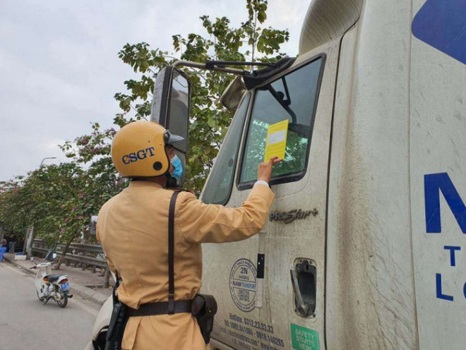Đội CSGT số 14 tiến hành dán thông báo phạt nguội xe container đỗ dừng trên đường Ngọc Hồi, TP Hà Nội