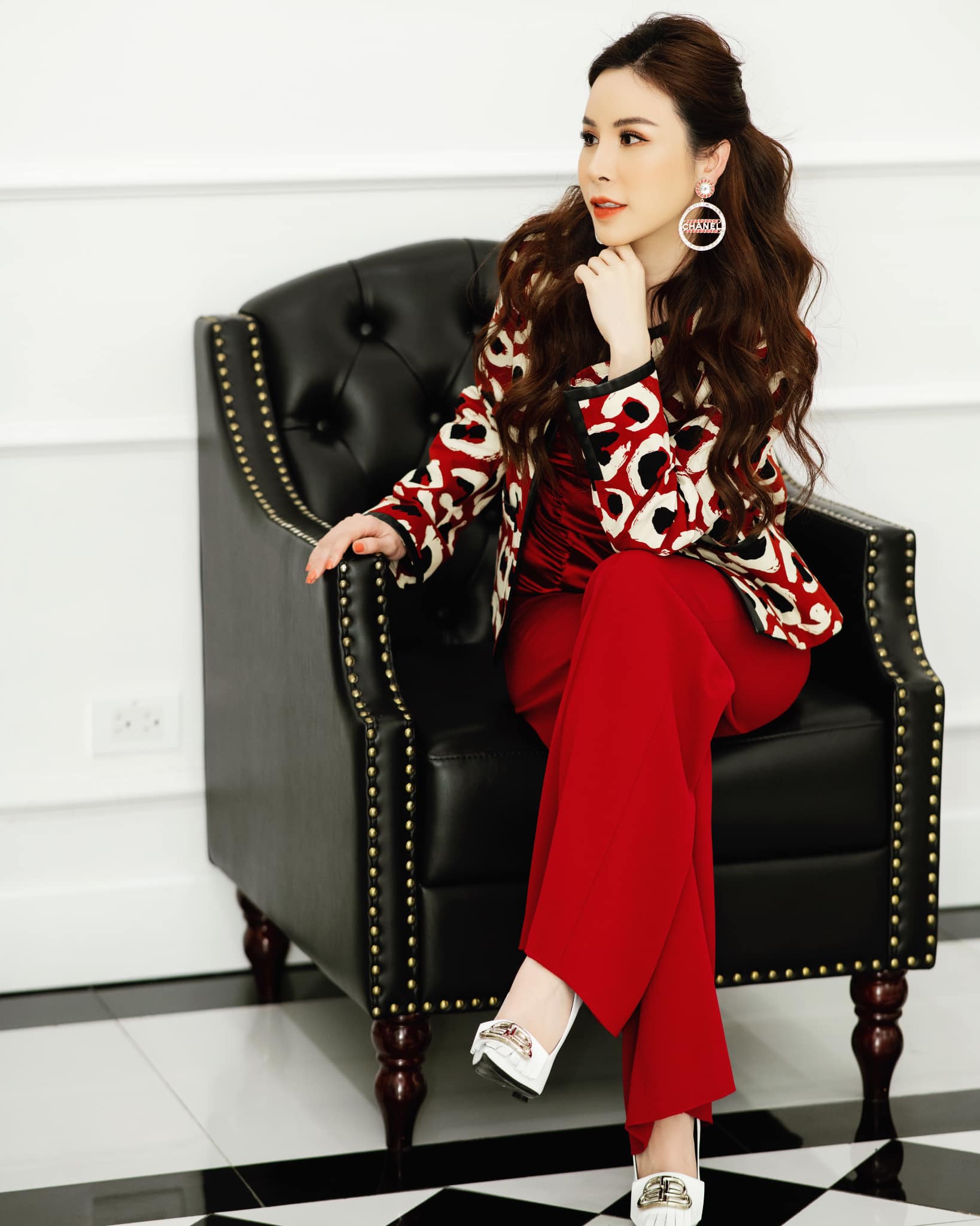 Hoa hậu Hoàng Dung gợi ý chọn bộ trang phục màu đỏ làm chủ đạo trong ngày đầu năm với mong muốn đem lại nhiều may mắn, đủ đầy. Áo khoác họa tiết mix "tone sur tone" với quần âu và corset lụa satin. Để diện mạo thêm phần đẳng cấp, cô dùng khuyên tai Chanel.