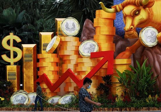Một người đàn ông đeo khẩu trang đi qua khu vực trang trí chuẩn bị cho năm mới âm lịch tại công viên Gardens by the Bay ở Singapore. Hình ảnh con trâu vàng biểu tượng cho năm Tân Sửu cũng hiện diện tại đây. Ảnh: Reuters