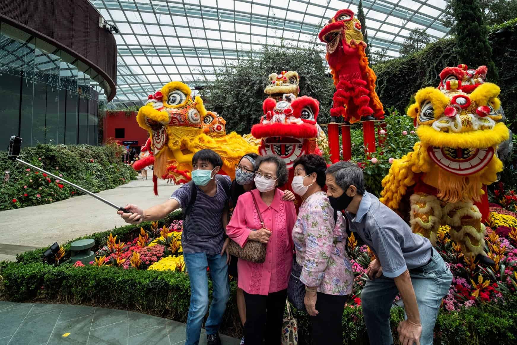 Một gia đình chụp ảnh tự sướng khi đeo khẩu trang trong lễ hội hoa thường niên Dahlia Dreams trước thềm Tết Nguyên đán ở Singapore. Ảnh: Reuters