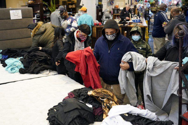 Người Mỹ đang chọn quần áo ấm được phát miễn phí tại một cửa hàng nội thất ở thành phố Houton khi mất điện trên diện rộng giữa mùa Đông khiến cuộc sống của họ đảo lộn và lâm vào tình thế nguy hiểm - ảnh AP.