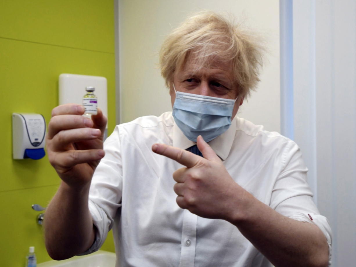 Thủ tướng Anh Boris Johnson cầm trên tay lọ vắc xin covid-19&nbsp;AstraZeneca&nbsp;(ảnh: NY Times)