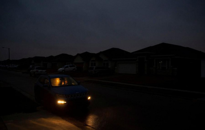 Một người phụ nữ ở trong xe hơi để
sưởi ấm cùng 2 đứa con vì điện bị cắt ở TP Corpus Christi, bang
Texas. Ảnh: Reuters