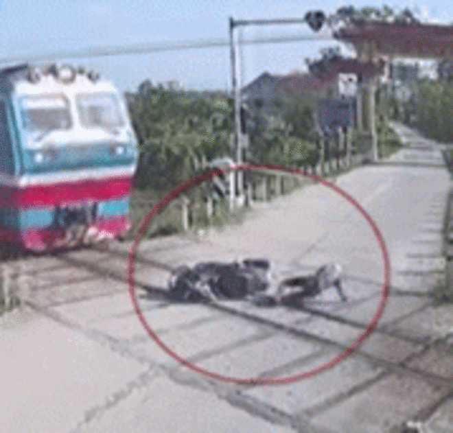 Video: Lái xe máy cố vượt barie đường sắt, suýt bị tàu hỏa nghiền nát - 1