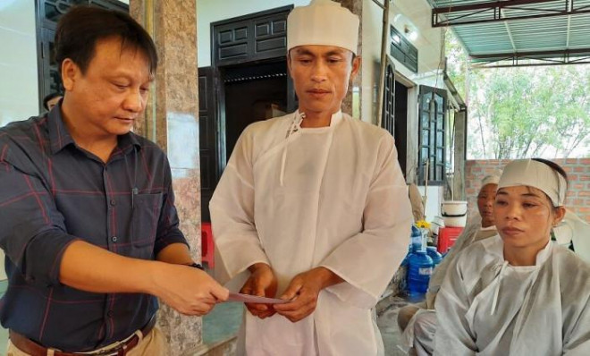 Ông Nguyễn Tấn Phương, Phó Chánh Văn phòng Ban ATGT tỉnh Quảng Trị trao tiền hỗ trợ của Ban ATGT tỉnh cho bố mẹ em Trịnh Thái Hai