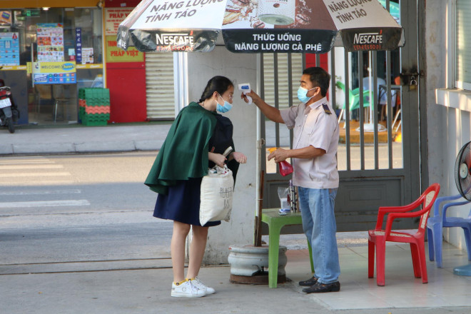 ... và đo thân nhiệt từ ngoài công trường
