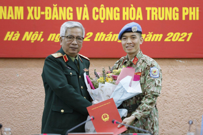 Thượng tướng Nguyễn Chí Vịnh, Thứ trưởng Bộ Quốc phòng, trao quyết định của Chủ tịch nước cho trung tá Trần Đức Hưởng sáng 12-3. Ảnh: TTXVN