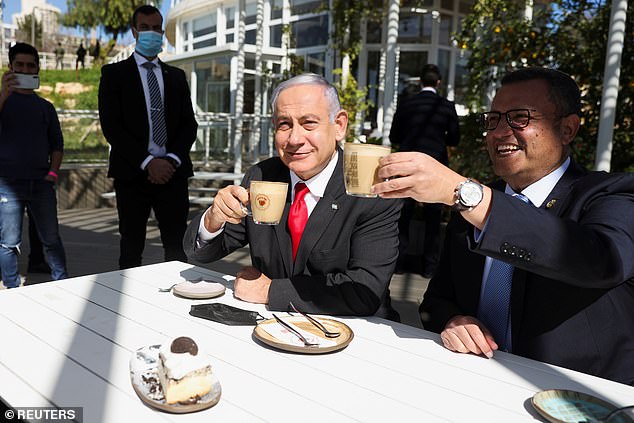 Thủ tướng Israel&nbsp;Benjamin Netanyahu (cà vạt đỏ) uống cà phê tại một quán ngoài trời hôm 7/3 khi quốc gia Trung Đông nới lỏng các lệnh hạn chế. Ảnh: Reuters