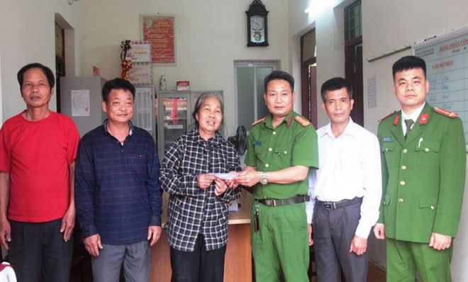 Ông Lê Đức Tiến đứng bên cạnh bà Mọc cùng Công an xã Hoằng Thịnh trao trả vàng cho người đánh rơi. Ảnh: CATH