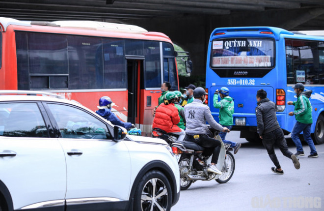 Nguy hiểm hơn, mỗi khi có ô tô dừng trả khách là cả nhóm tài xế xe ôm thi nhau chạy đua, thậm chí lao ra giữa đường để giành khách (ảnh chụp chiều 22/3).