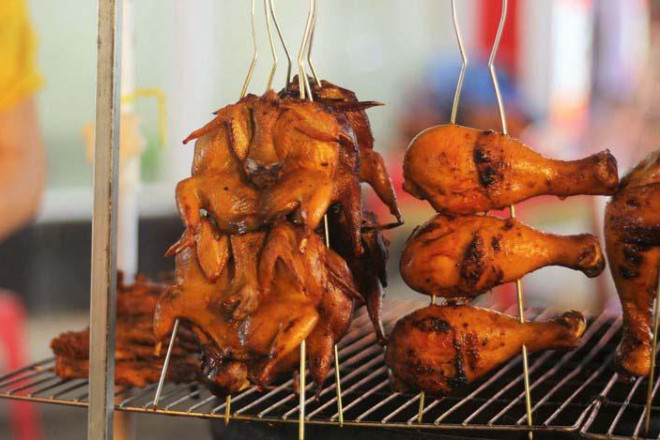 Gà nướng nguyên con là món ngon chợ đêm Phú Quốc không thể thiếu. Trước khi nướng gà được phết một lớp mật ong, khi chín bề ngoài có màu vàng óng ánh. (Ảnh: Zingnews)
