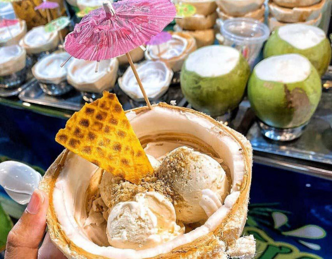 Đến chợ đêm Phú Quốc, nhiều du khách không thể bỏ qua món kem trái dừa hấp dẫn. Những viên kem mát lạnh được đựng trong nửa trái dừa đã cắt gọt khéo léo, thêm các loại topping, trang trí thêm chiếc dù nhỏ xinh. Bạn có thể chọn hương vị kem tùy theo ý thích. (Ảnh: sưu tầm)