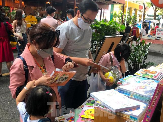 Một gia đình trẻ đưa con đi chơi, chọn mua sách.