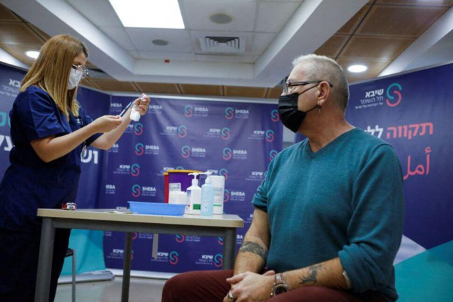 Một người đàn ông chuẩn bị tiêm mũi vắc-xin Covid-19 thứ tư ở Israel ngày 31-12-2021. Ảnh: Reuters