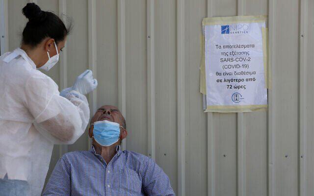 Một nhân viên y tế xét nghiệm cho người dân ở Larnaca, Cyprus. Ảnh - AP