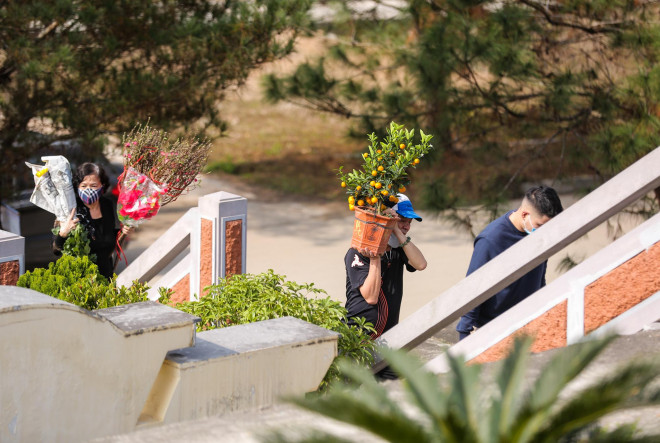 Những chậu đào, quất được các gia đình mang đến phần mộ người đã khuất, tô điểm sắc xuân cho khung cảnh nơi đây