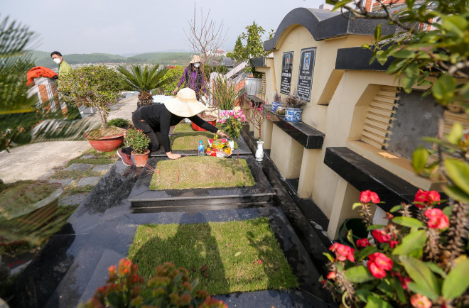 Con cháu bày biện hương hoa trước phần mộ người thân