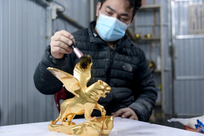 Sau đó, với những lá vàng 24k, người thợ sẽ thực hiện phủ vàng lên thân tượng