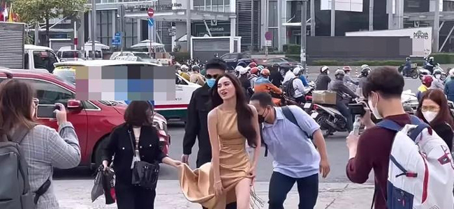 Nữ diễn viên 9X được fan quay lại khoảnh khắc cùng ê-kíp xuống phố. Vì trang phục cắt xẻ bạo nên Lan Ngọc thường xuyên phải lấy tay giữ.
