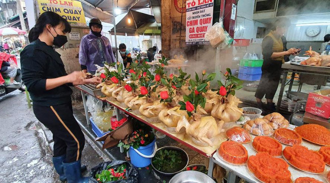 Gà luộc sẵn ngậm hoa hồng được bày bán nhiều tại chợ Hàng Bè.