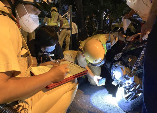 CSGT Tân Sơn Nhất kiểm tra số khung số máy trước khi niêm phong xe máy. Ảnh: LÊ THOA