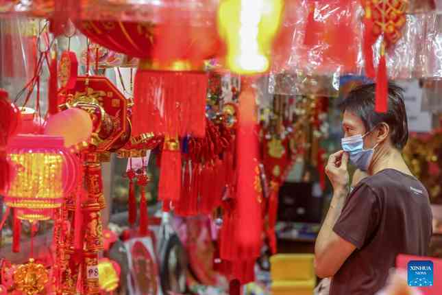 Một cư dân Manila (Philippines) chăm
chú chọn mua đồ trang trí năm mới. Ảnh: Tân Hoa Xã