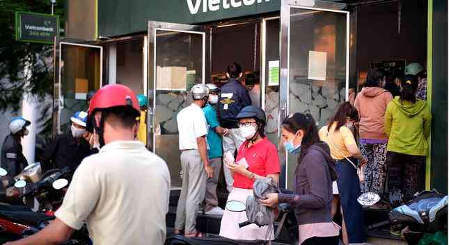 Theo ghi nhận của PV Tiền Phong, ngày 27/1, sau giờ tan ca, khá đông người đến giao dịch rút tiền tại ATM khu chế xuất Tân Thuận (quận 7). Tại đây, bên trong mỗi buồng ATM chật cứng người, bên ngoài là hàng chục người kiên nhẫn xếp hàng chờ đến lượt.